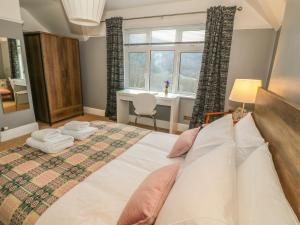 a bedroom with a large bed and a window at Coedfryn in Betws-y-coed