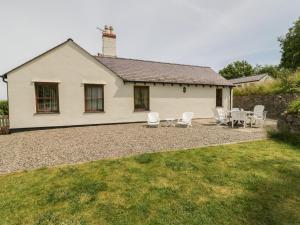 une maison avec des chaises et une table devant elle dans l'établissement Pen Y Bryn Cottage, à Llandudno Junction