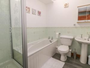 a bathroom with a tub and a toilet and a sink at 2 Bryn Eglwys in Porthmadog +18 photos