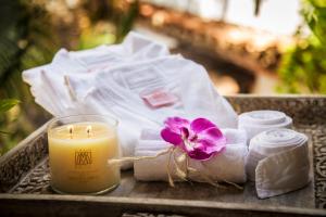 a candle and towels and a flower on a table at Hotel El Marqués by Faranda Boutique in Cartagena de Indias