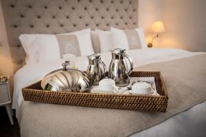 bandeja con set de té en una cama en Hotel El Marqués by Faranda Boutique en Cartagena de Indias
