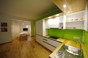 una cocina con armarios verdes y blancos y una mesa en Vannucci House, en Perugia