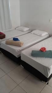 Tres camas en una habitación con toallas. en Flats Residence Bueno, en Goiânia