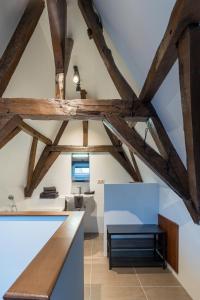 una cocina en el ático con vigas de madera y una mesa. en Logement de Spaerpot, en Middelburg