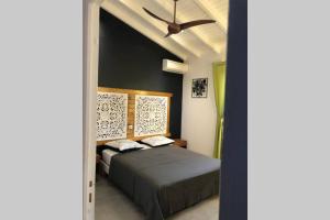 a bedroom with a bed and a ceiling fan at chez SAM in Grand-Bourg