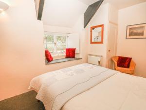 a bedroom with a large bed and a window at Churchgate Cottage in Bodmin