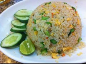 a white plate with rice and cucumbers and a rice ball at Yahle Villa เยห์เล่วิลล่า in Chao Lao Beach