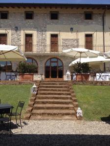 a building with stairs and umbrellas in front of it at Villa Redona in Entratico