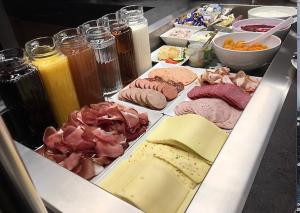a table topped with different types of meats and cheese at Alpenhotel Weiherbach Berchtesgaden Hallenbad und Sauna in Berchtesgaden