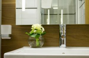 um vaso de flores sentado em cima de um lavatório em Hôtel-Restaurant du Cerf em Sonceboz