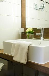 y baño con lavabo blanco y espejo. en Hôtel-Restaurant du Cerf en Sonceboz