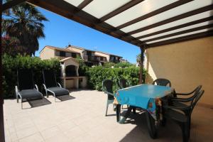 eine Terrasse mit einem blauen Tisch und Stühlen auf einer Terrasse in der Unterkunft Domaine de vacances à 600m de la plage animations piscines en supplément belle villa climatisée 3 chambres 6 couchages WIFI LRPDSK3 in Portiragnes