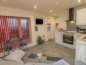 a kitchen and living room with a couch and a table at The Old Sty in Whiston
