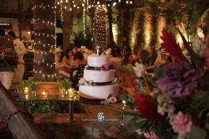 a wedding cake sitting on top of a table with people at Hotel El Marqués by Faranda Boutique in Cartagena de Indias