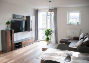 a living room with a couch and a tv at Apartment von Schivelbusch in Markkleeberg
