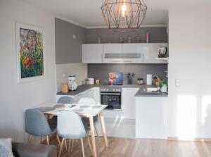 a kitchen with a white table and chairs in a room at Apartment von Schivelbusch in Markkleeberg