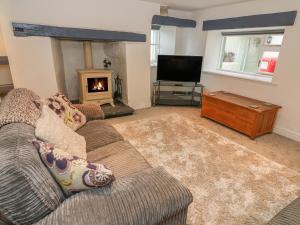 a living room with a couch and a fireplace at The Cottage in Grange Over Sands