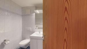 un baño con inodoro y lavabo en Splendura 2A, en Silvaplana