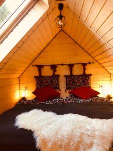een bed in een houten kamer met een bontjas bij Chata Pod Lasem in Poręba