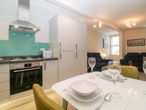 a kitchen and dining room with a white table with wine glasses at Apartment 18 in Newton Abbot