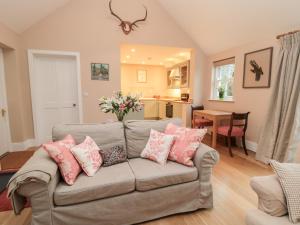 a living room with a couch with pink pillows at The Garden Room in Hexham