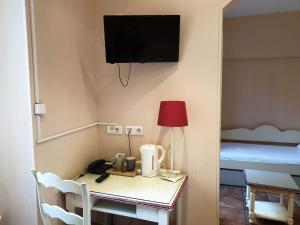 
a room with a television and a lamp at Hôtel Bonaparte in Toulon
