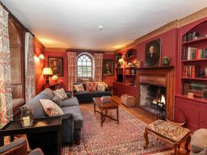 a living room with red walls and a fireplace at Battel Hall in Maidstone