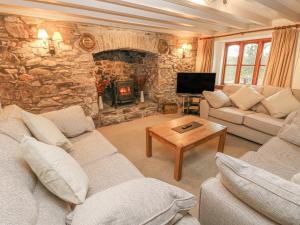 - un salon avec des canapés et une cheminée en pierre dans l'établissement Maerdy Lodge, à Haverfordwest