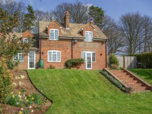 a large brick house with a grass yard at Knights Cottage in Maidstone