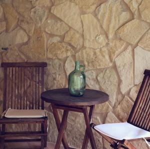 a vase sitting on a table next to two chairs at Finca Ses Eres in Artá