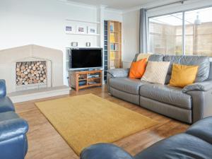 a living room with a couch and a tv at Bay View Cottage in Newport-On-Tay
