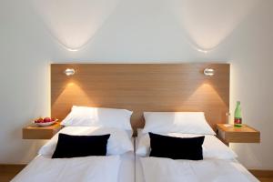 a bedroom with two beds and a wooden headboard at Hotel Ploberger in Wels