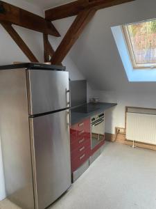 una cucina con frigorifero in acciaio inossidabile in mansarda di Zur Lutherkanzel a Jena
