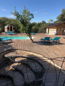 eine Gruppe Bänke neben einem Pool in der Unterkunft Spa Les Jardins De Chiron Lodges et Tiny House dans le sud in Sauve