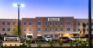 Un gran edificio con coches aparcados en un estacionamiento. en Staybridge Suites - Vero Beach by IHG, en Vero Beach