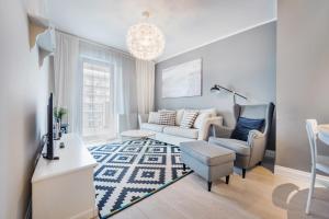a living room with a couch and a chair at Apartamenty Sun & Snow Cztery Oceany in Gdańsk