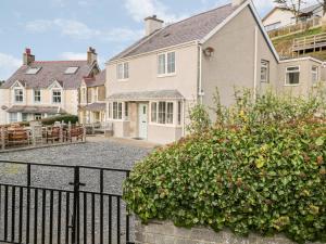 a large white house with a black fence at Castell in Pwllheli