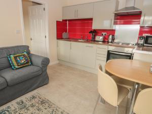 eine Küche mit einem Sofa und einem Tisch in einem Zimmer in der Unterkunft Vallum Kiosk in Hexham