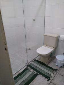 a bathroom with a shower with a toilet and a rug at Apartamento in Porto Seguro