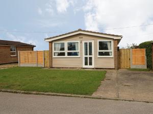 a small house in a yard with a fence at Moggs Retreat in Skegness