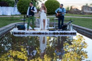 Ein Mann und eine Frau stehen mit einer Gitarre auf einer Bühne. in der Unterkunft Hattonchatel Château & Restaurant La Table du Château in Hattonchâtel