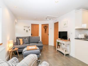 a living room with a couch and a tv at Ysgubor Llwyd in Holyhead