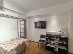 バレンシアにあるApartment La Marinaのベッド1台と壁掛けテレビが備わる客室です。