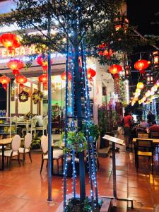 un ristorante con un albero in mezzo a una strada di Elisa Hotel a Ninh Binh