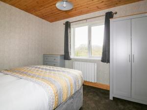 a bedroom with a bed and a window at Lodge Two in Truro