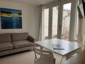 a living room with a table and a couch at Bell Cottage in Mildenhall