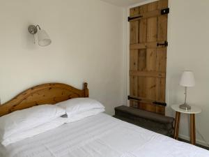 a bedroom with a bed and a wooden door at Bell Cottage in Mildenhall