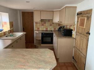 mała kuchnia ze zlewem i kuchenką w obiekcie Bell Cottage w mieście Mildenhall +25 zdjęć