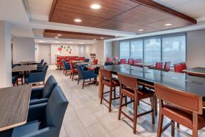 a dining room with tables and chairs at Holiday Inn Express & Suites West Long Branch - Eatontown, an IHG Hotel in West Long Branch
