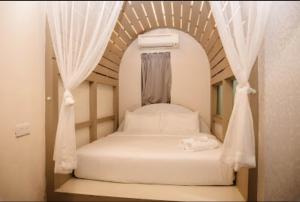 a bedroom with a bed in an arch with curtains at Vivids Hotel in Kuala Lumpur